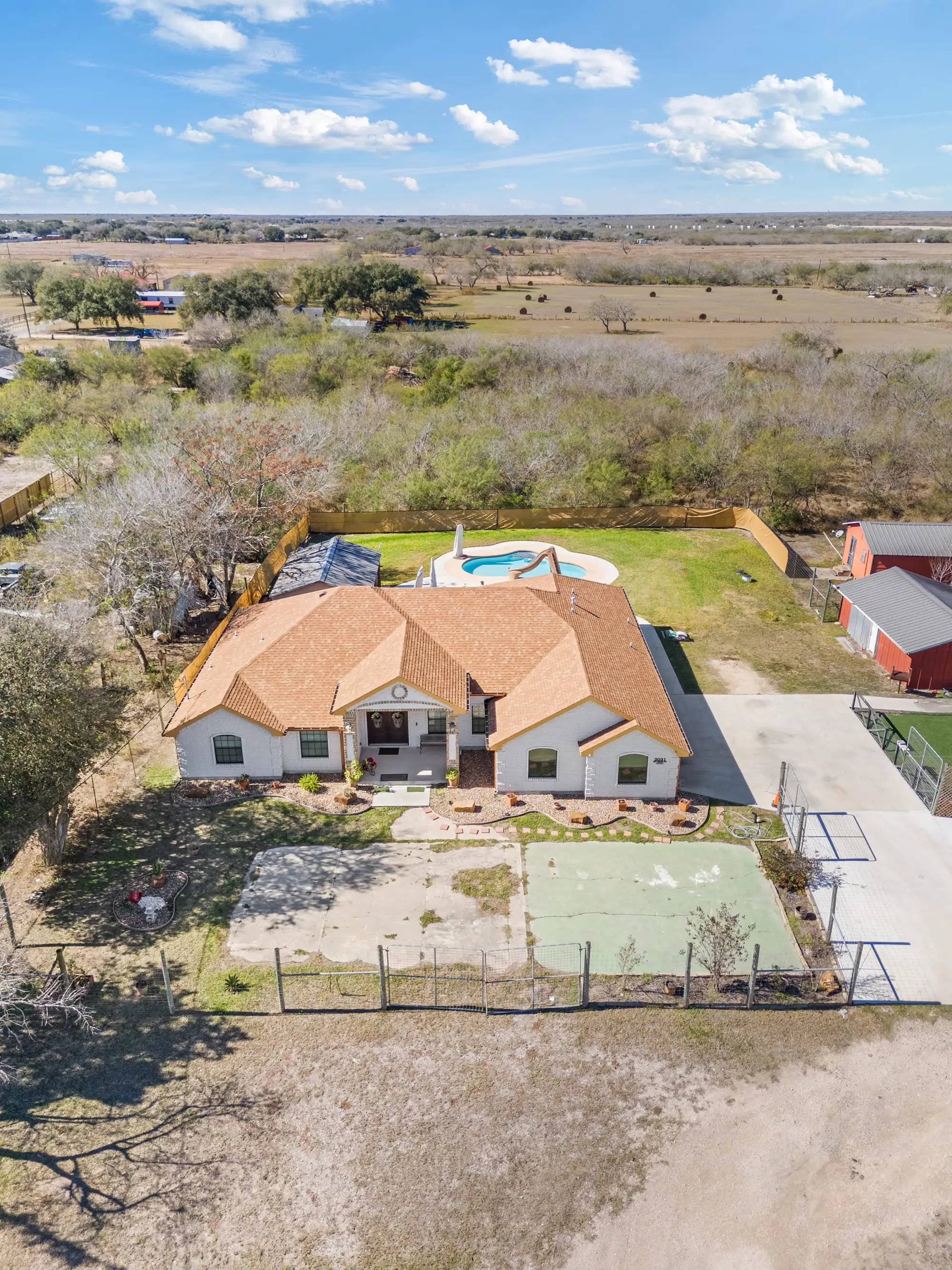 Aerial of the full property with the house, court and outbuildings