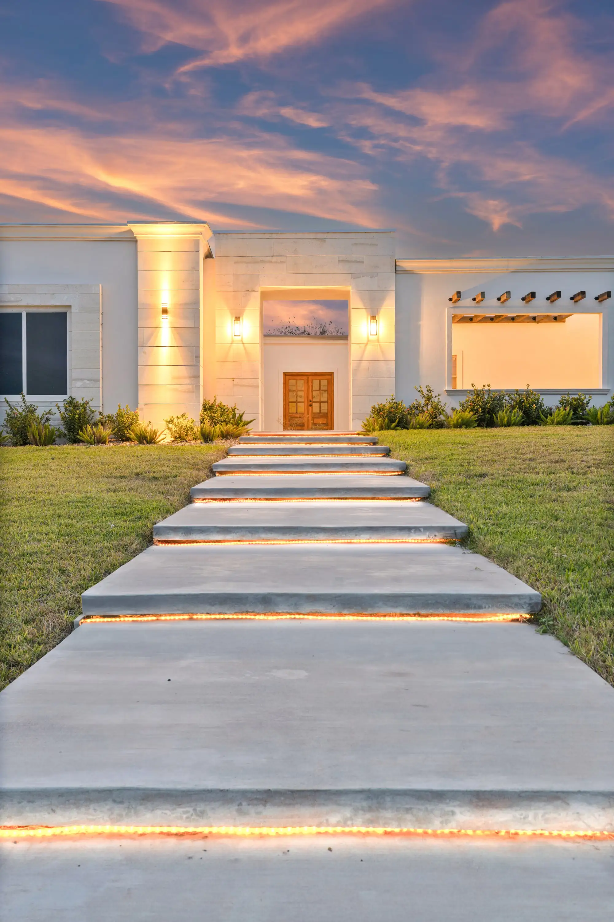 Entry stair and uplit entry tower after sunset