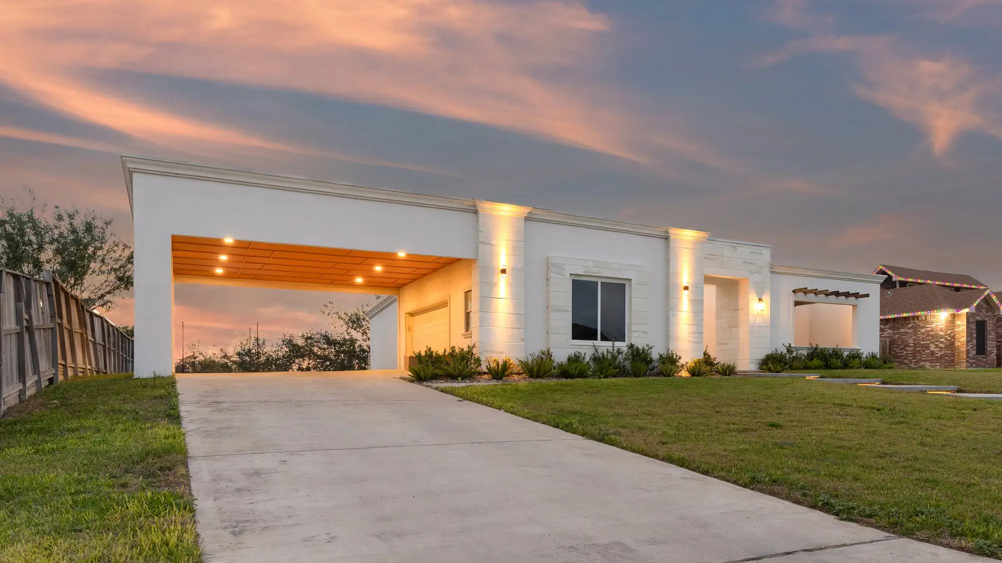 Lit porte-cochère with a wood-slat soffit over the concrete drive