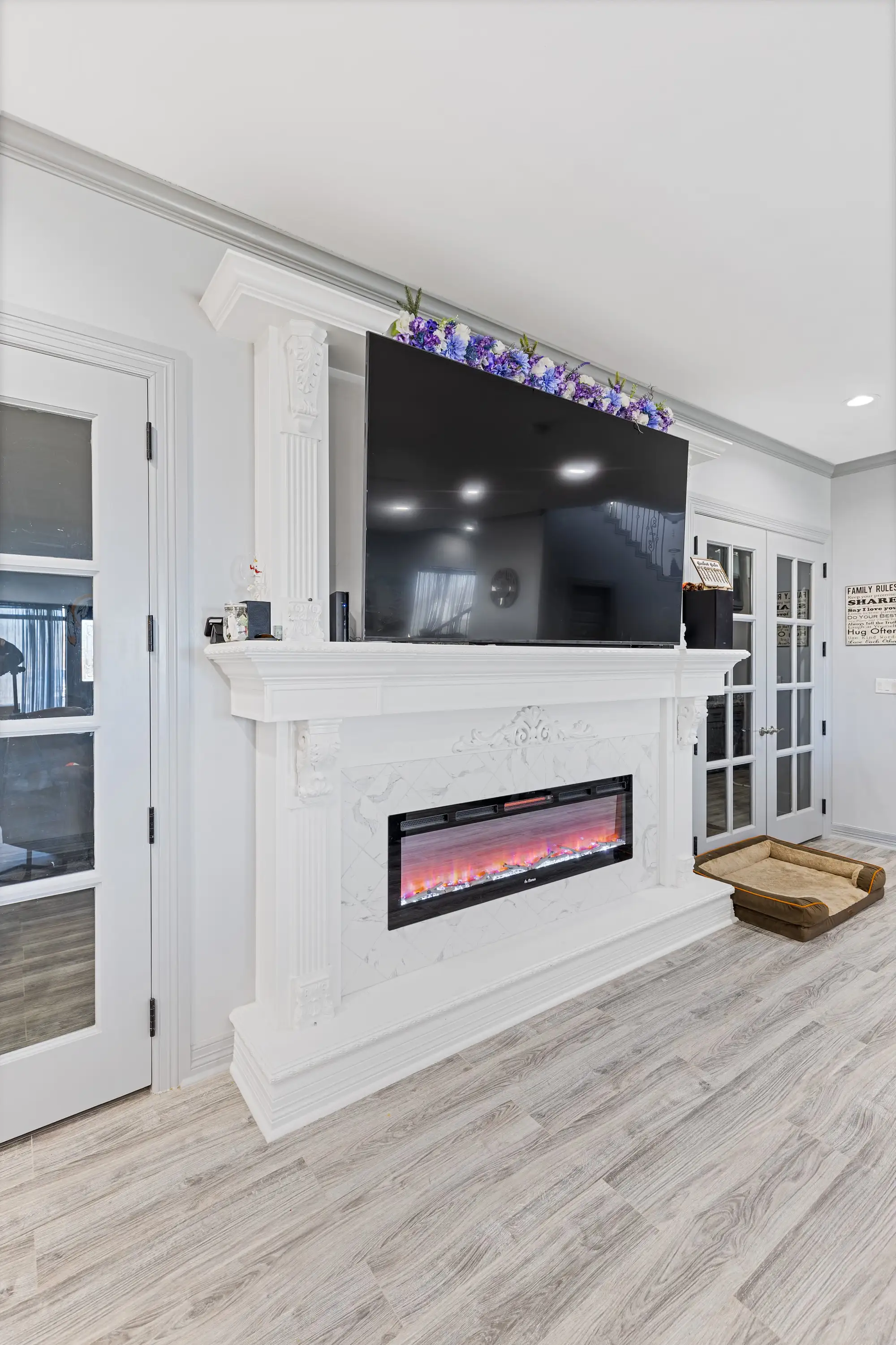 White marble fireplace surround with the television above the mantel