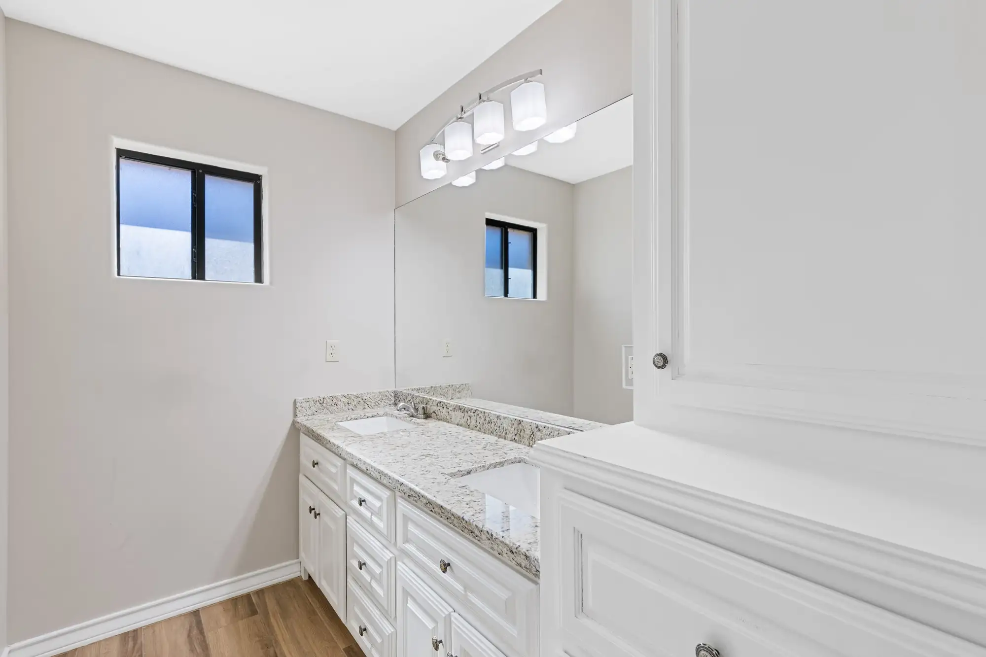 Secondary bath with a granite-topped vanity and a three-light fixture