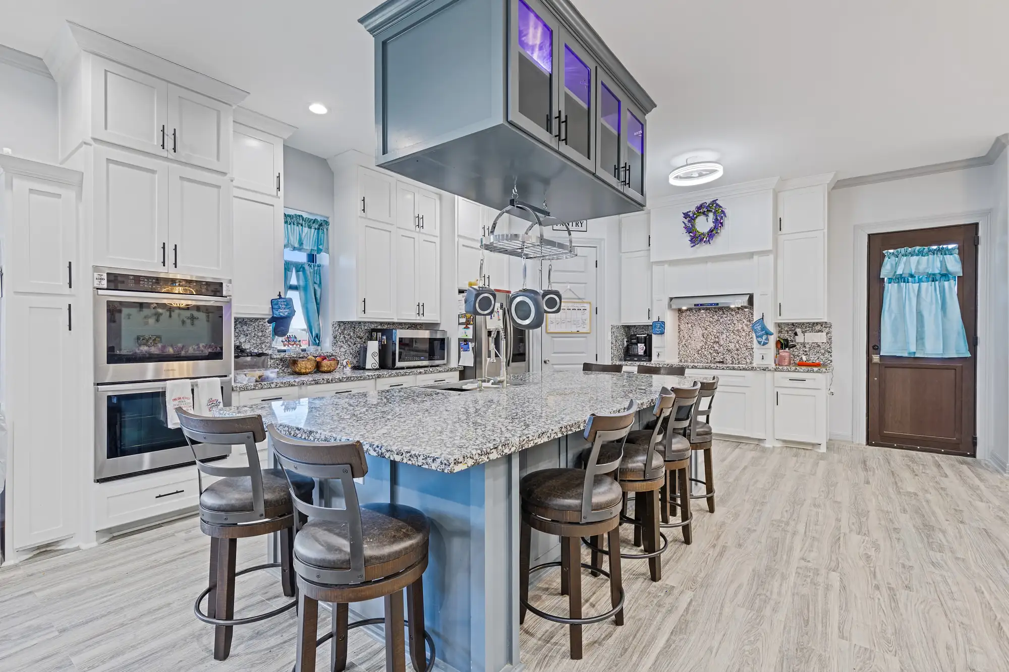 Kitchen bar with granite counters, a recessed hood and counter stools