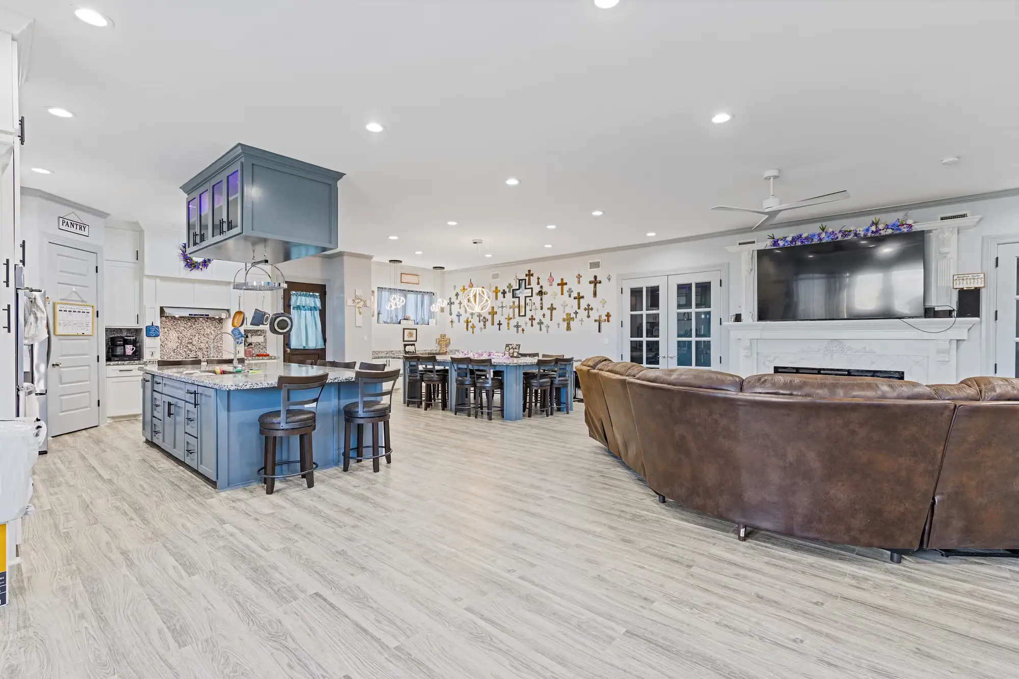 Open kitchen with a blue island, breakfast bar and the living area in the same volume