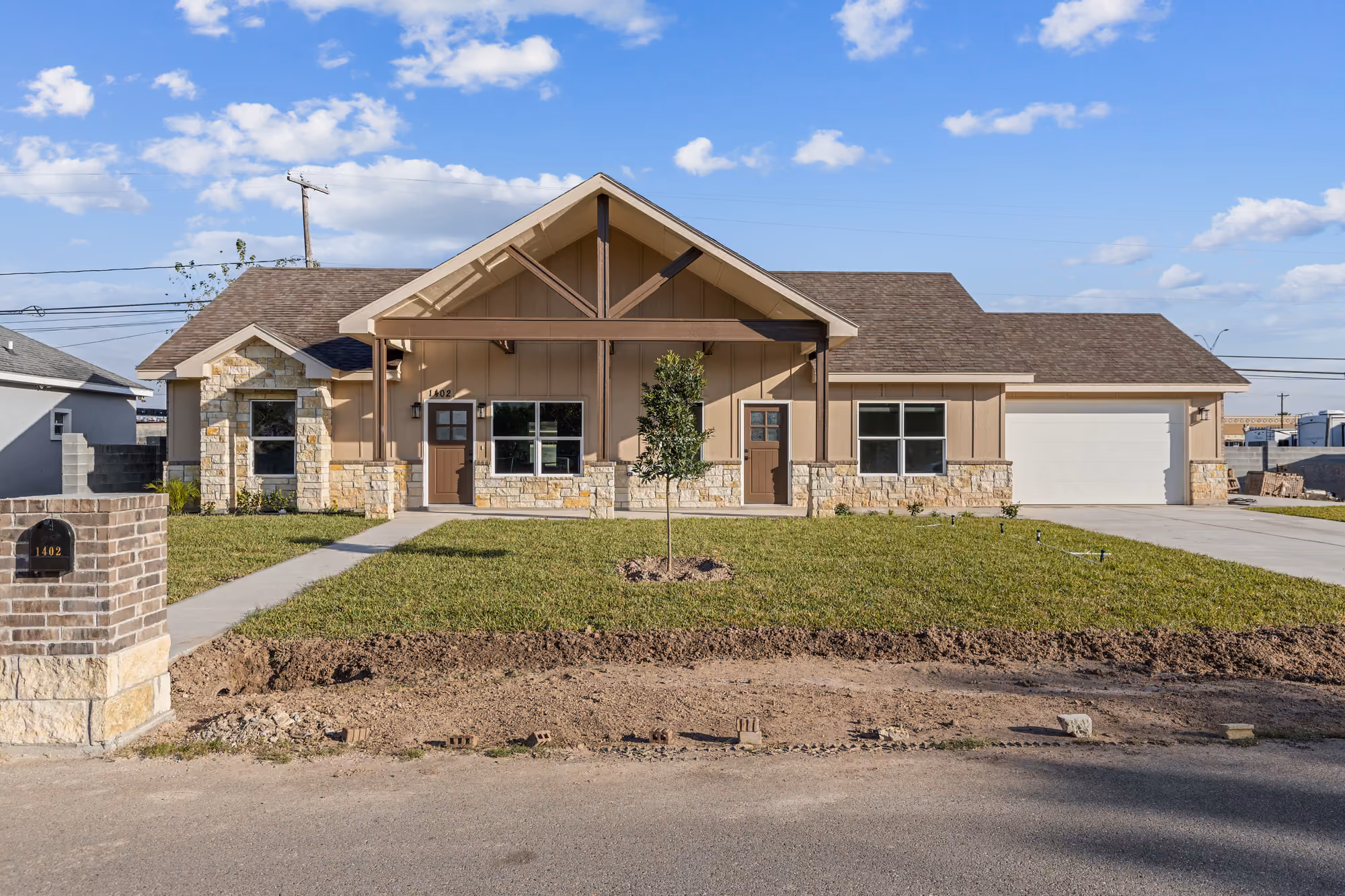 Farmhouse-inspired elevation with an exposed timber porch and stone base