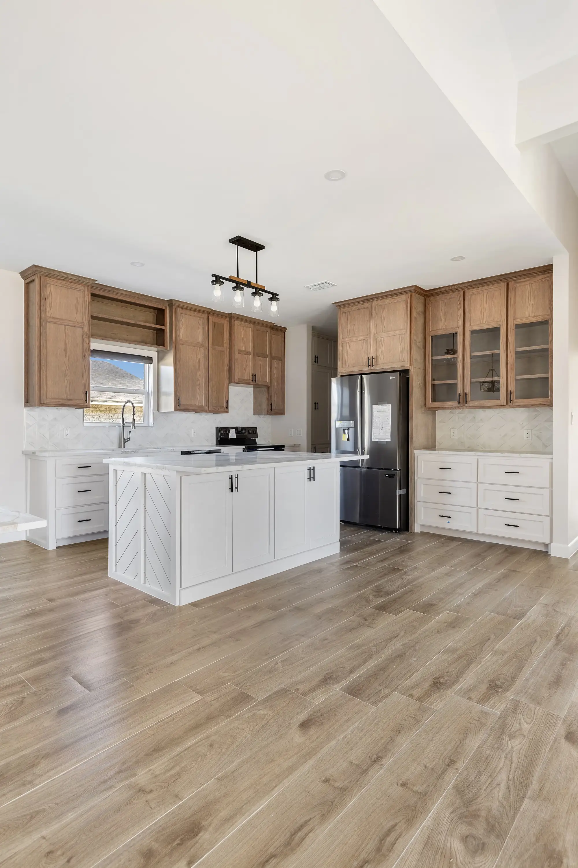 Kitchen run detail with the range, glass cabinet and built-in refrigerator