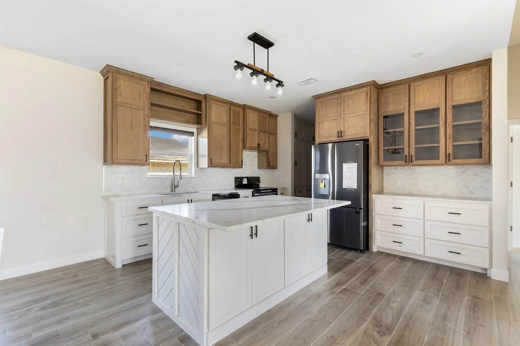 Full kitchen with glass-front uppers, a recessed hood and a breakfast bar
