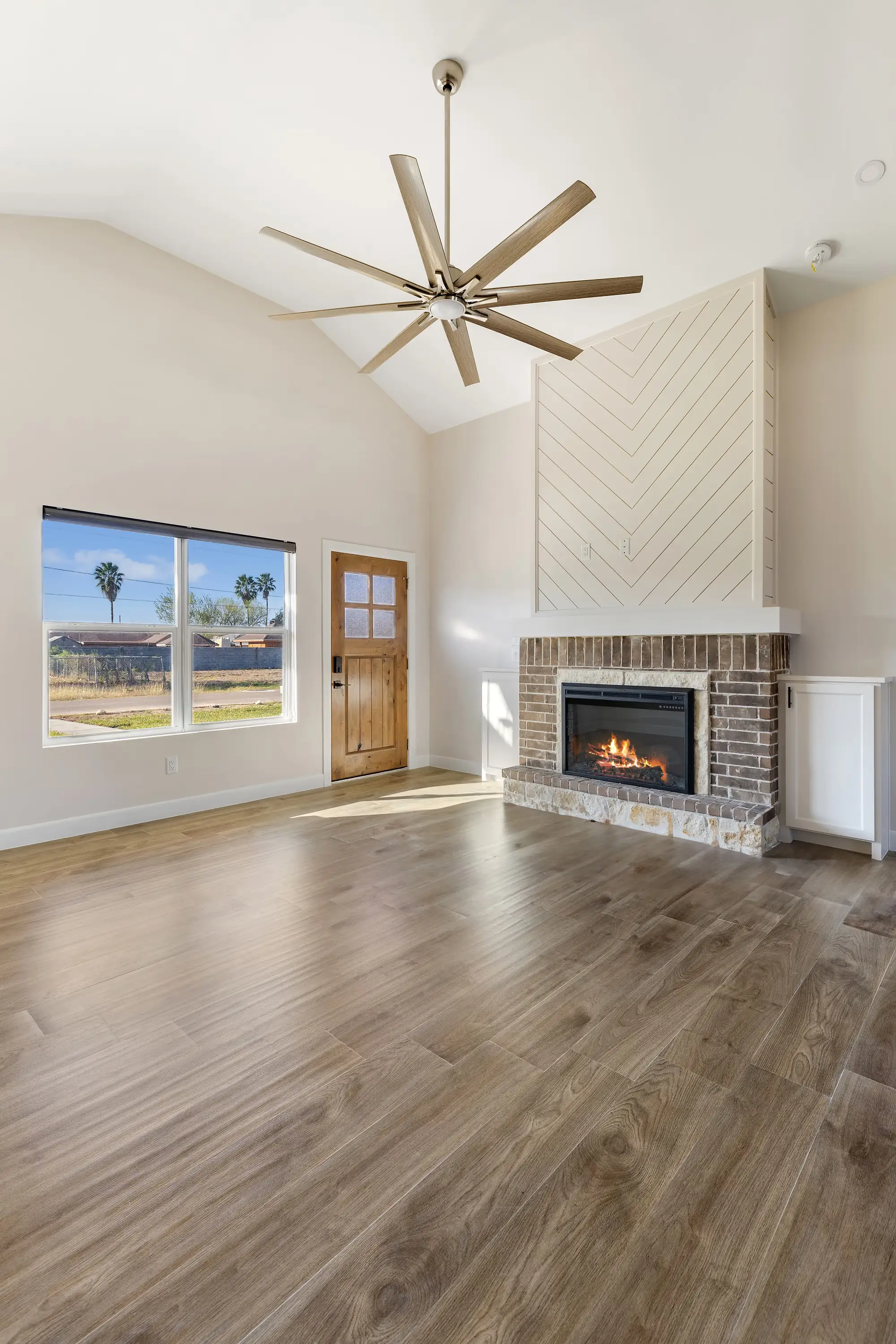 Living room lit by the front window and the wood entry door