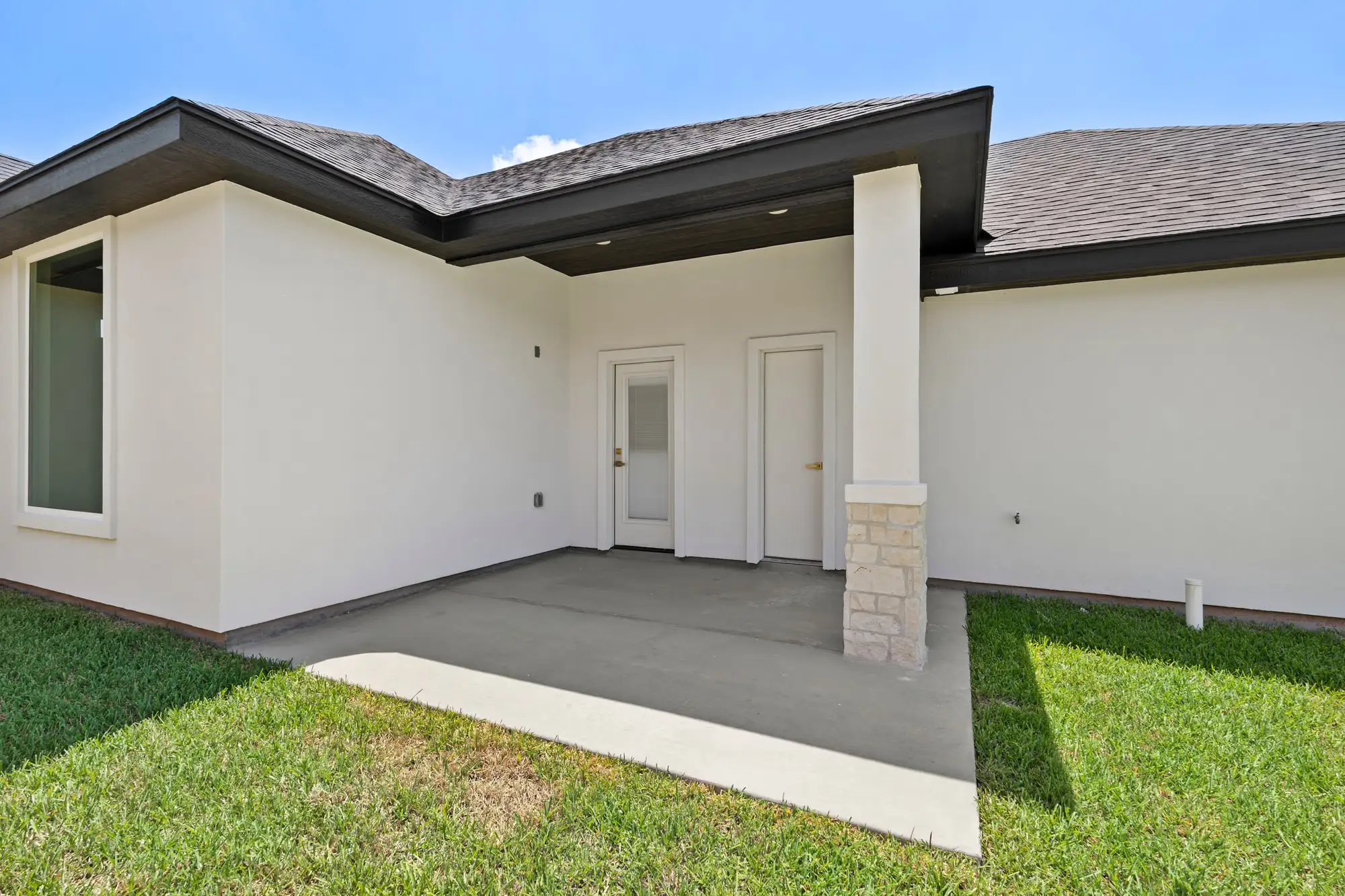 Covered rear patio in finished concrete opening straight onto the yard