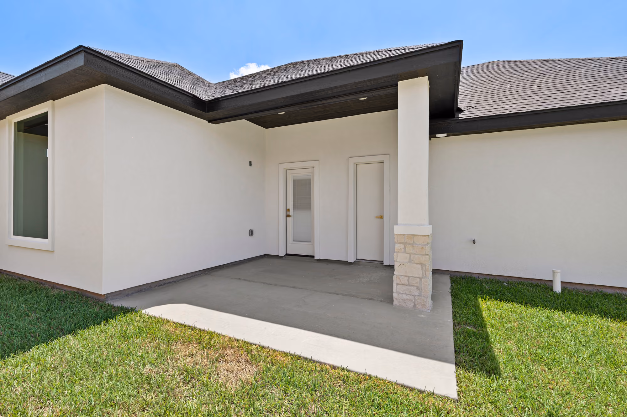 Covered rear patio in finished concrete opening straight onto the yard