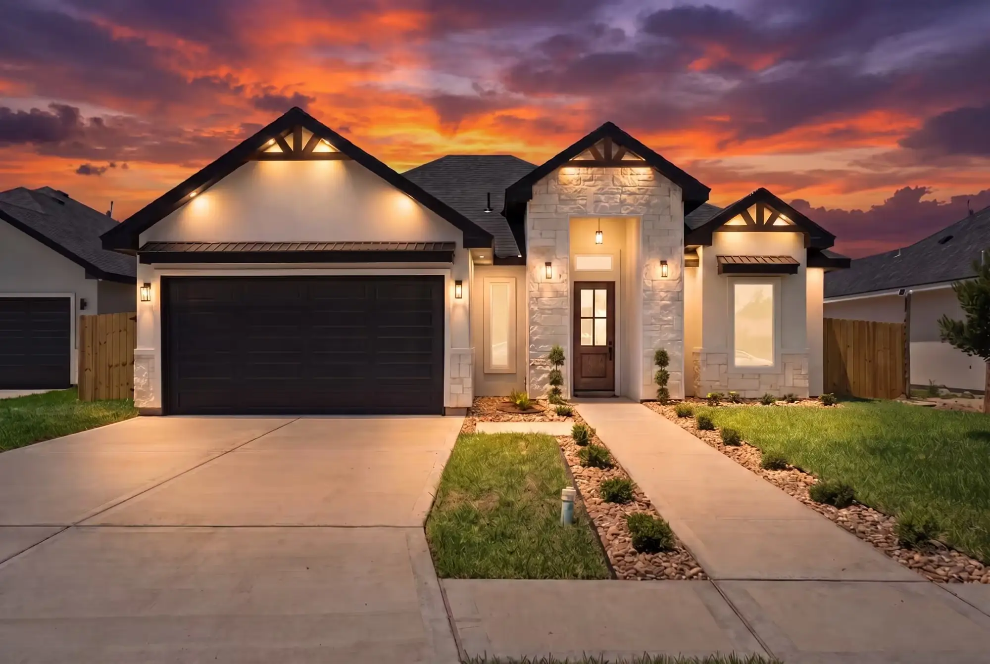 The Laguna Oaks home at dusk, gabled roofline against a lit sky with the entry walk glowing