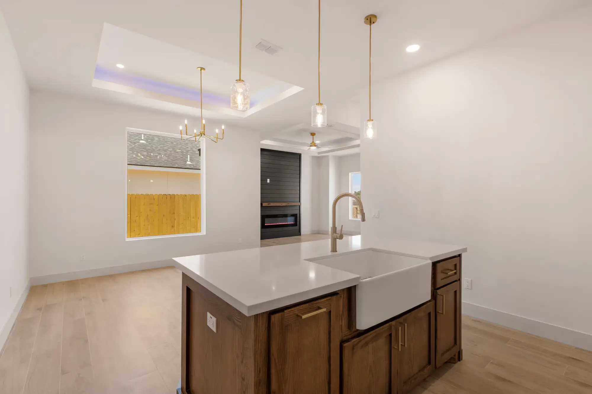 Kitchen opening into the dining area under a sculptural fixture, with daylight from the patio