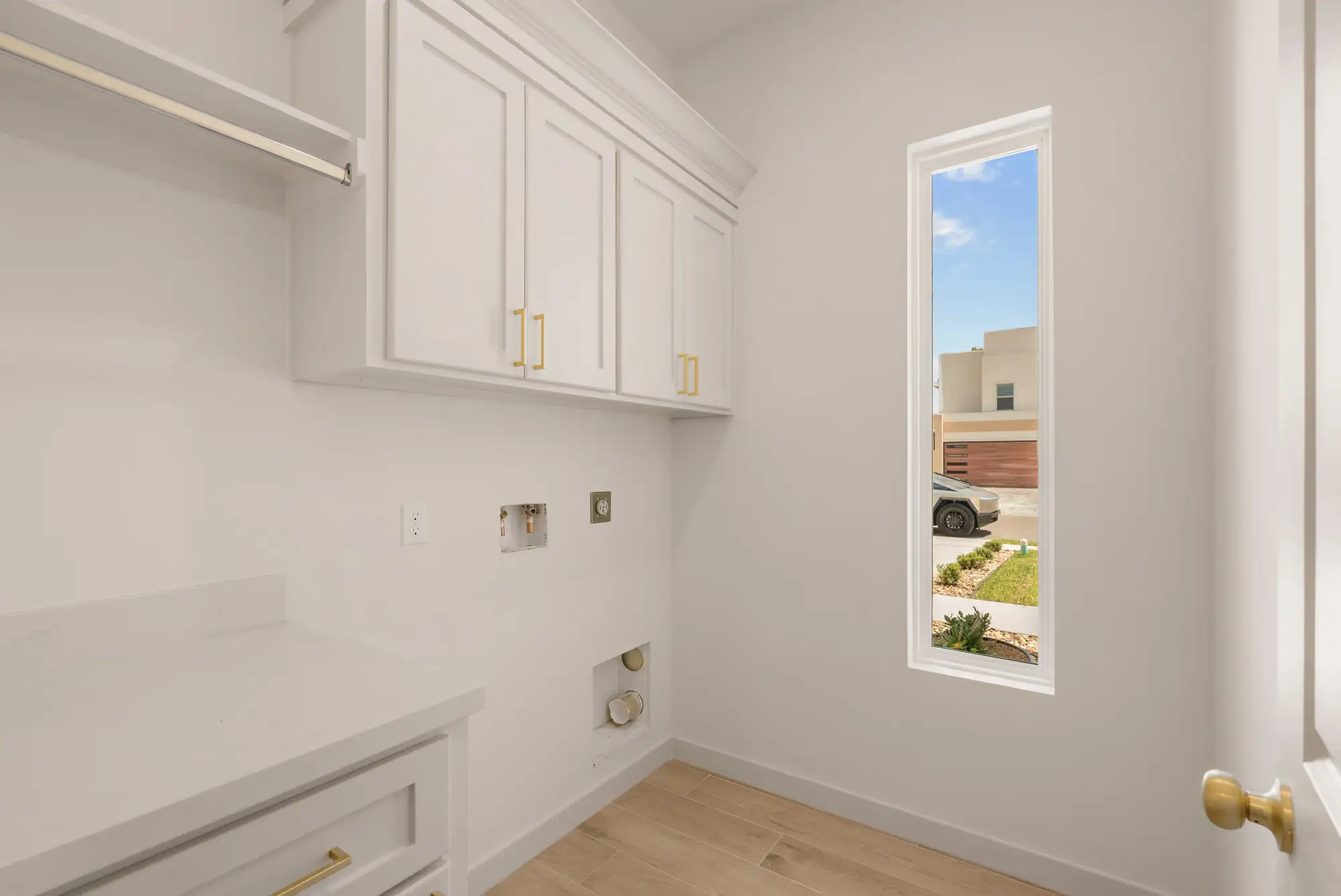 Laundry room with upper cabinets, a folding counter and a natural-light window