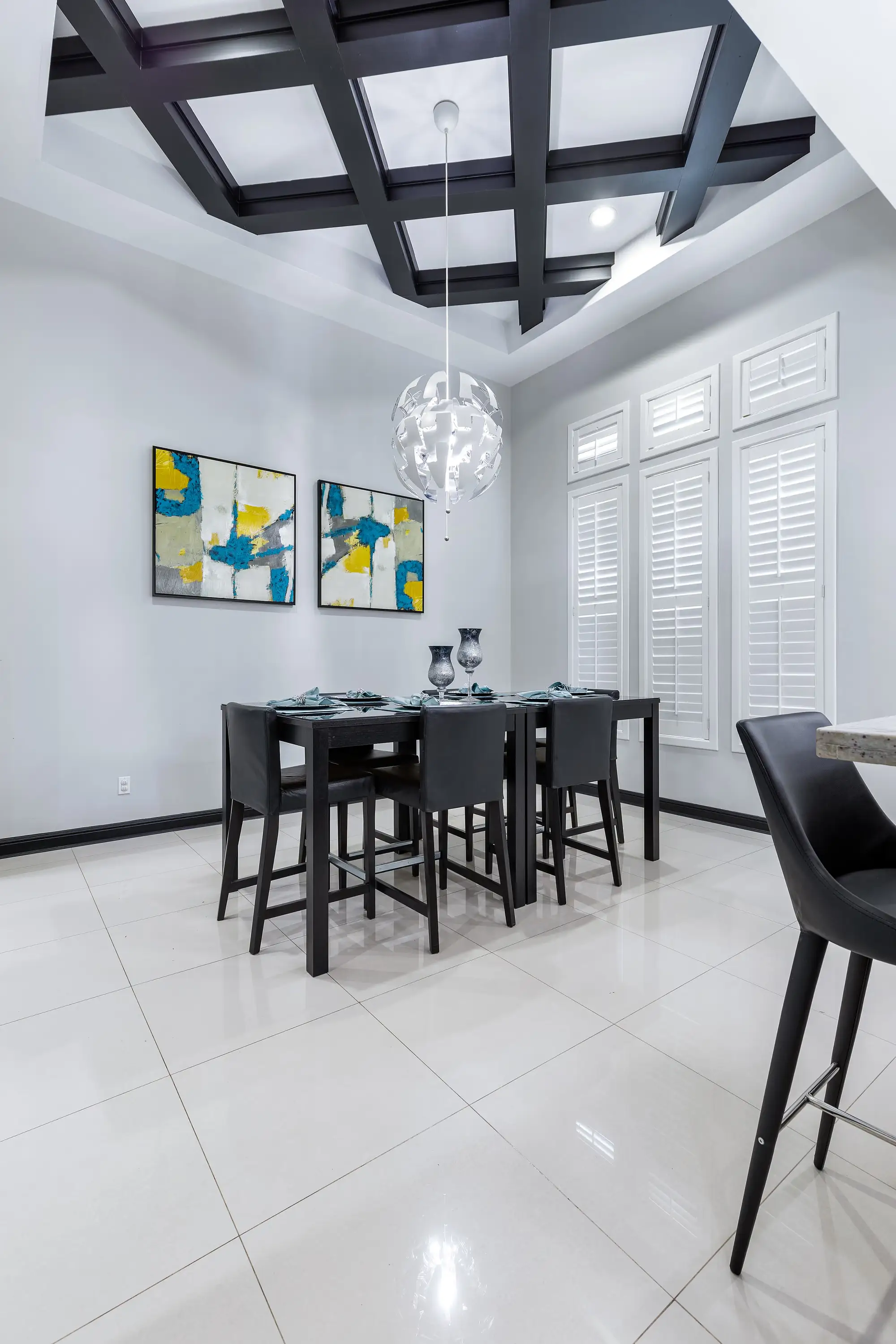 Formal dining under a dark-stained coffered ceiling and a spherical fixture