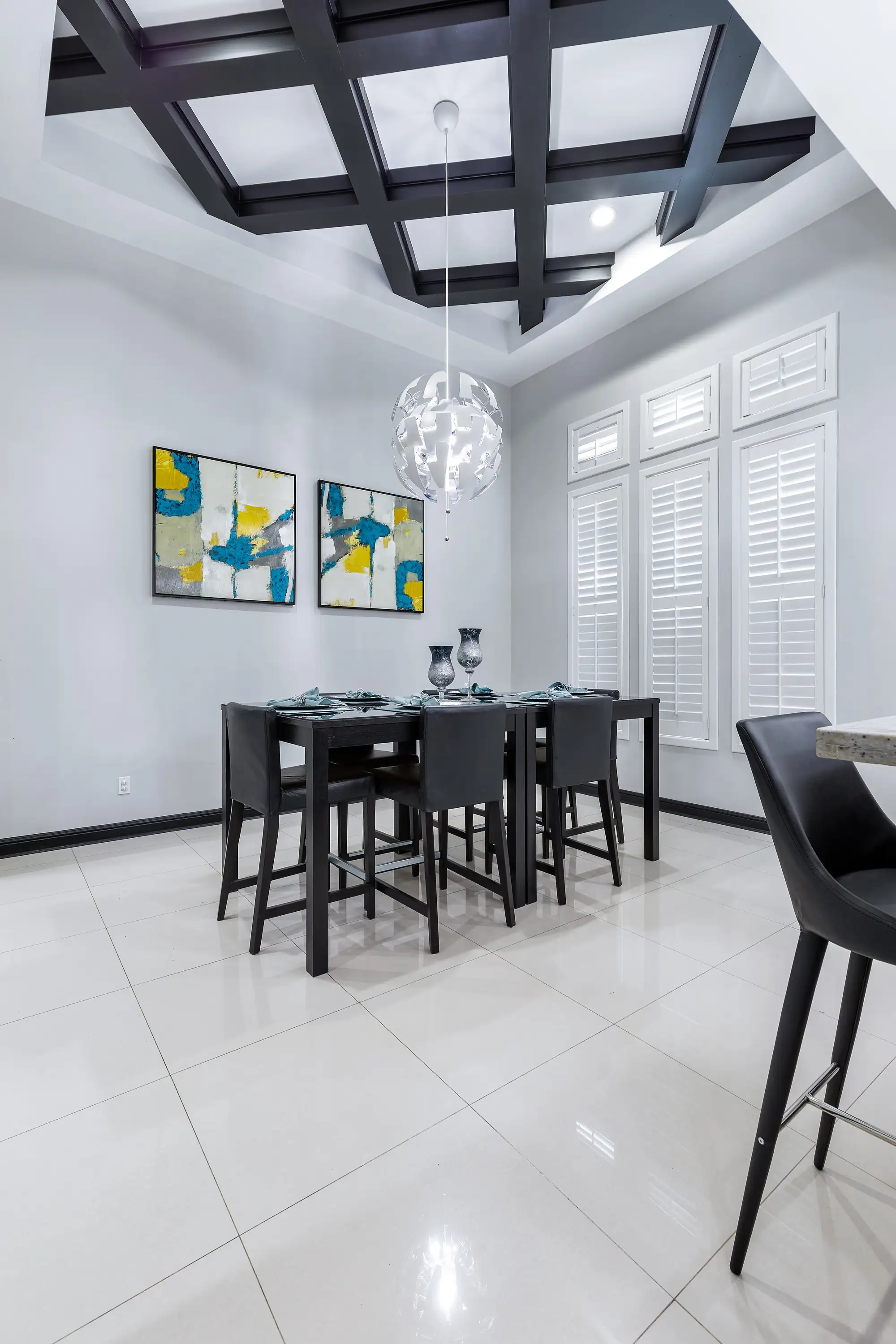 Formal dining under a dark-stained coffered ceiling and a spherical fixture