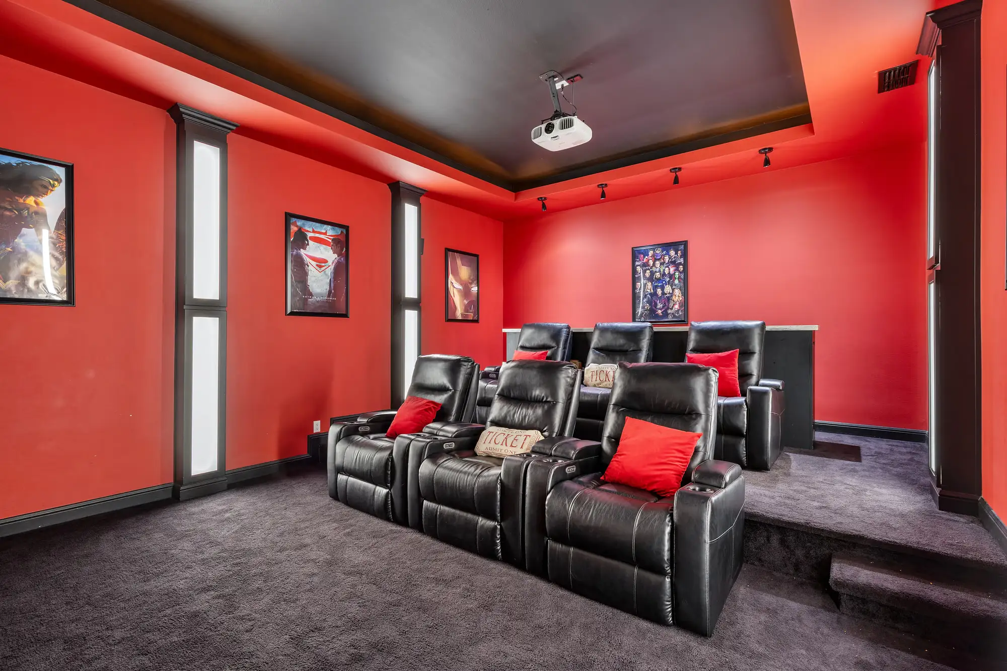 Home theater with tiered recliners against an acoustically treated red wall
