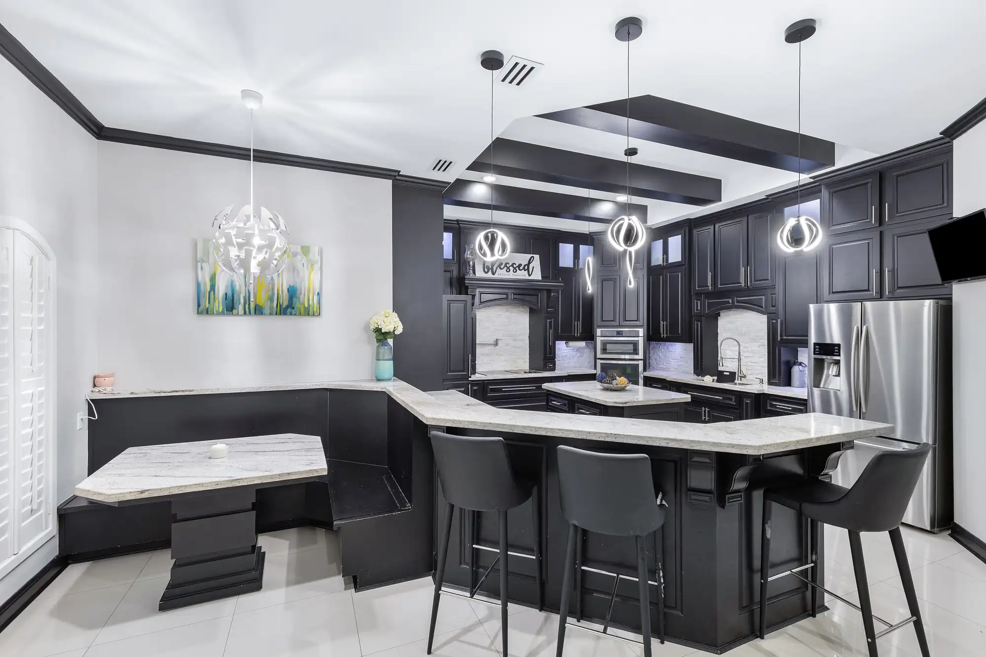 Kitchen island with breakfast bar, stacked dark cabinetry and a framed hood