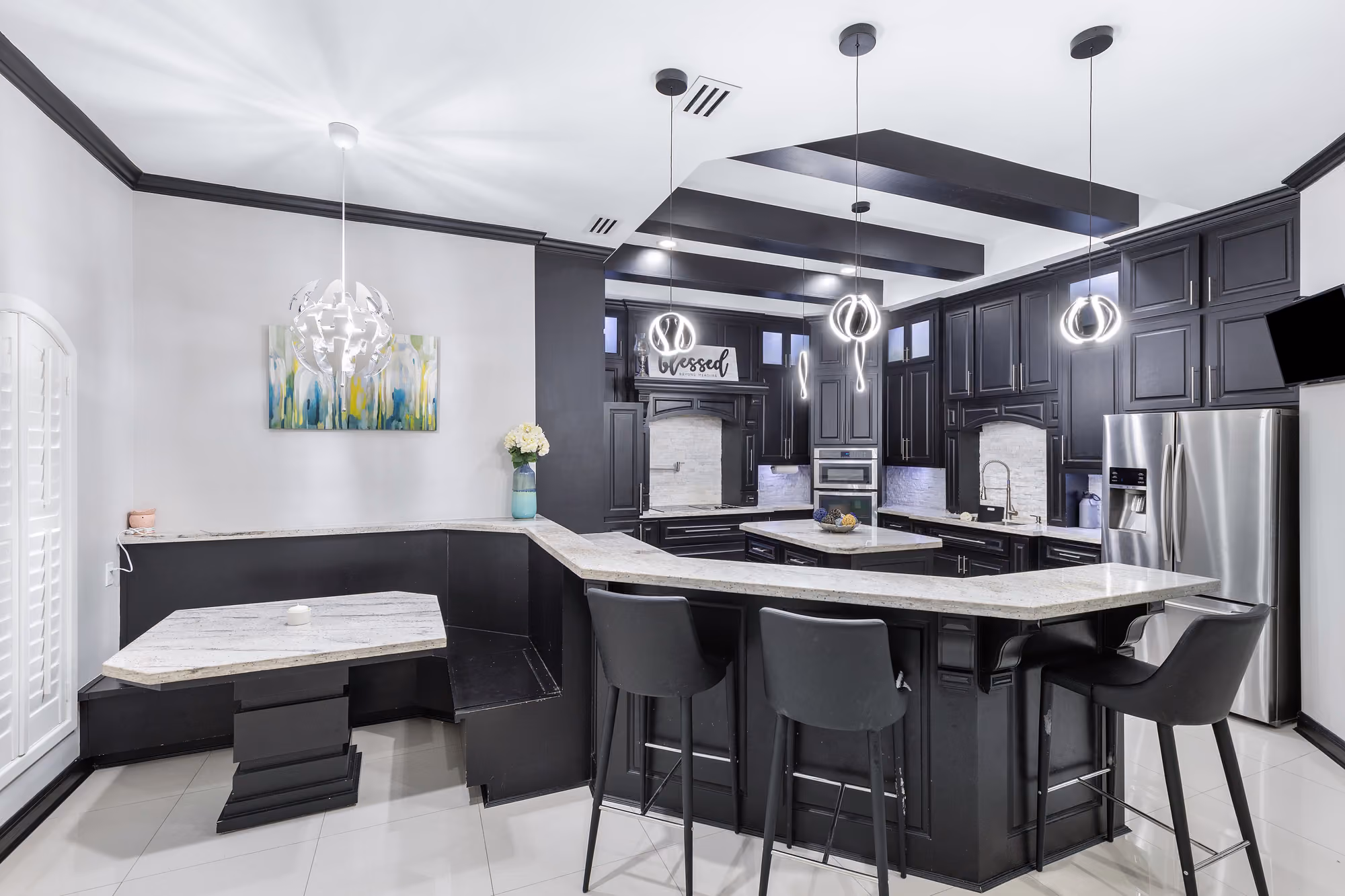 Kitchen island with breakfast bar, stacked dark cabinetry and a framed hood