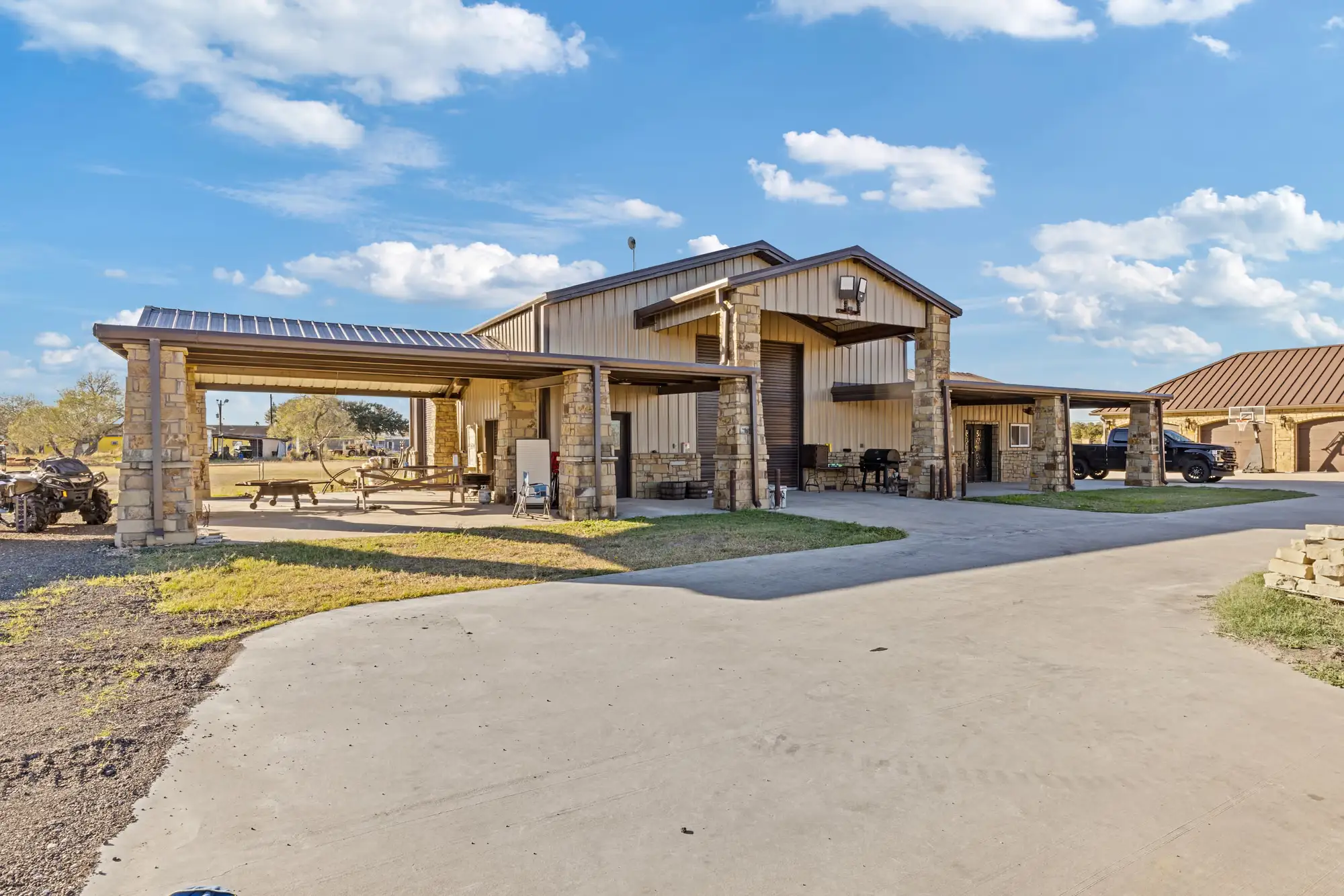Stone outbuilding with a covered lounge and attached carport