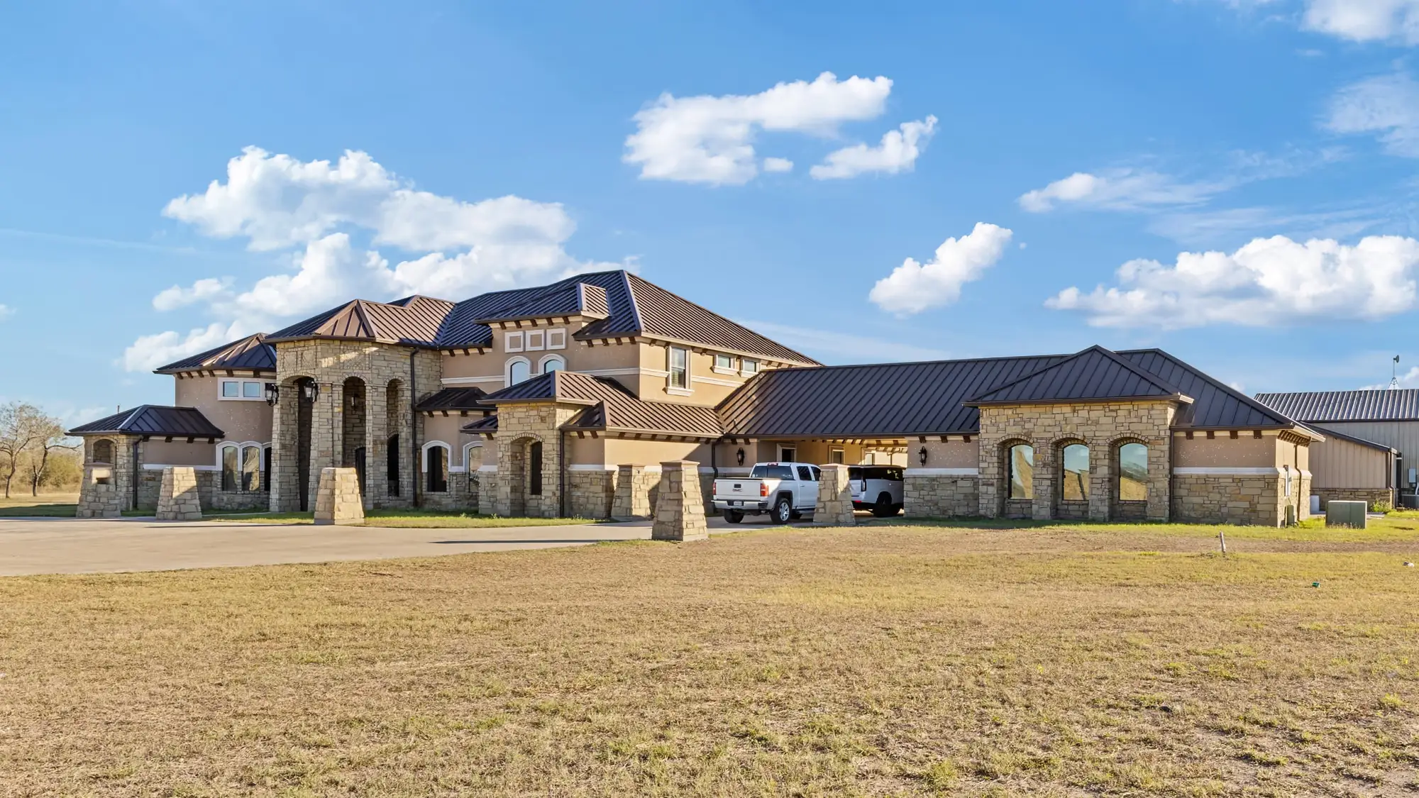 Two-story wing of the residence seen across open ground