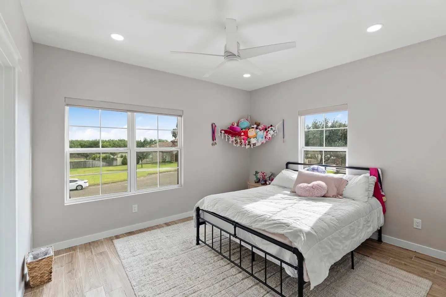 Secondary bedroom with a wide window and engineered wood flooring