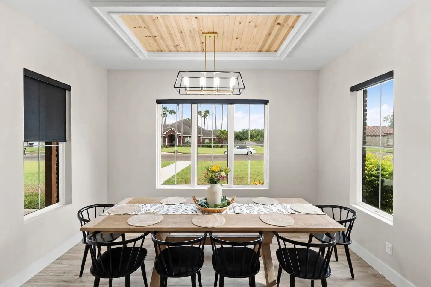 Dining room with a planked ceiling, table for eight and a linear fixture