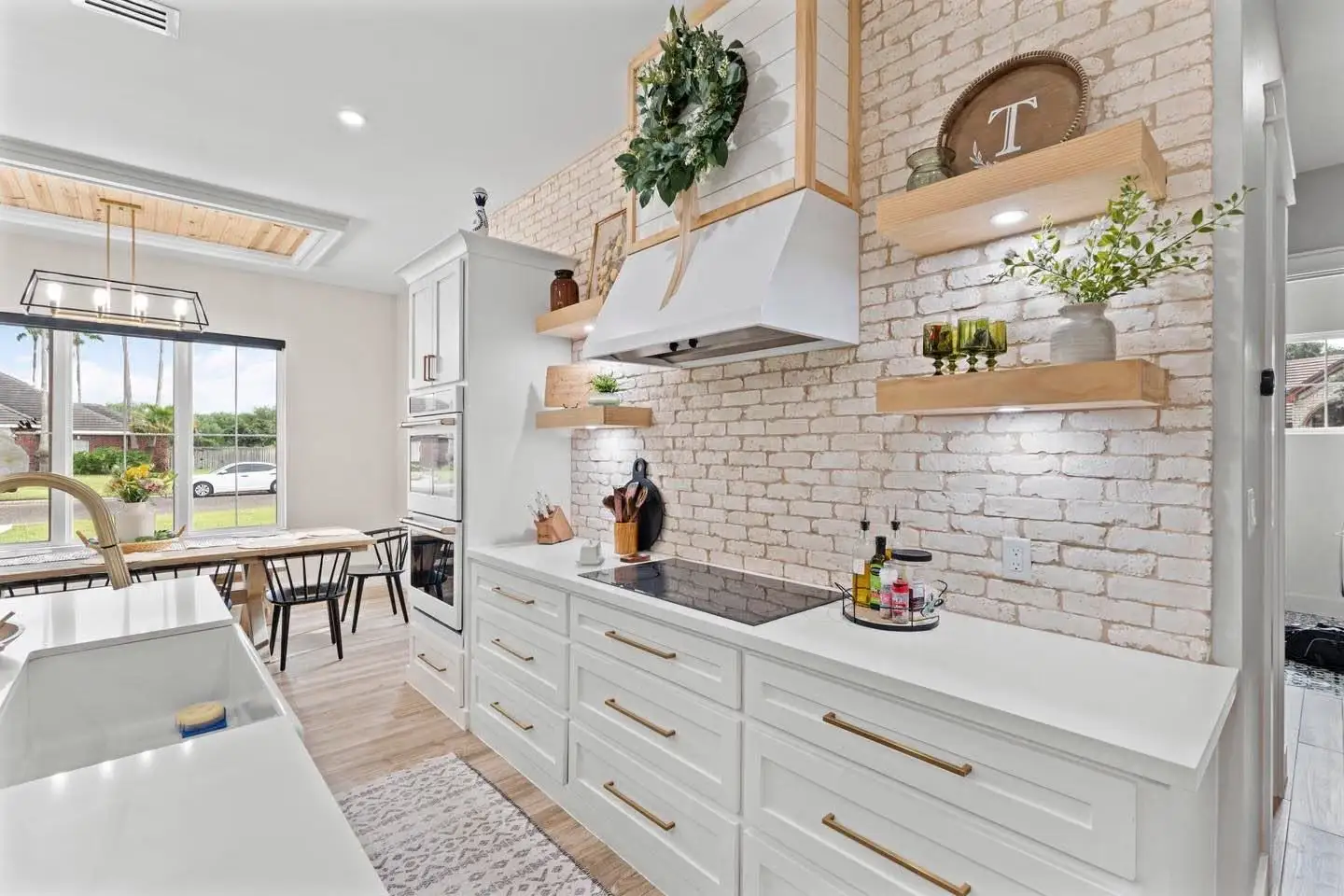White brick backsplash, wood-wrapped hood and quartz counters