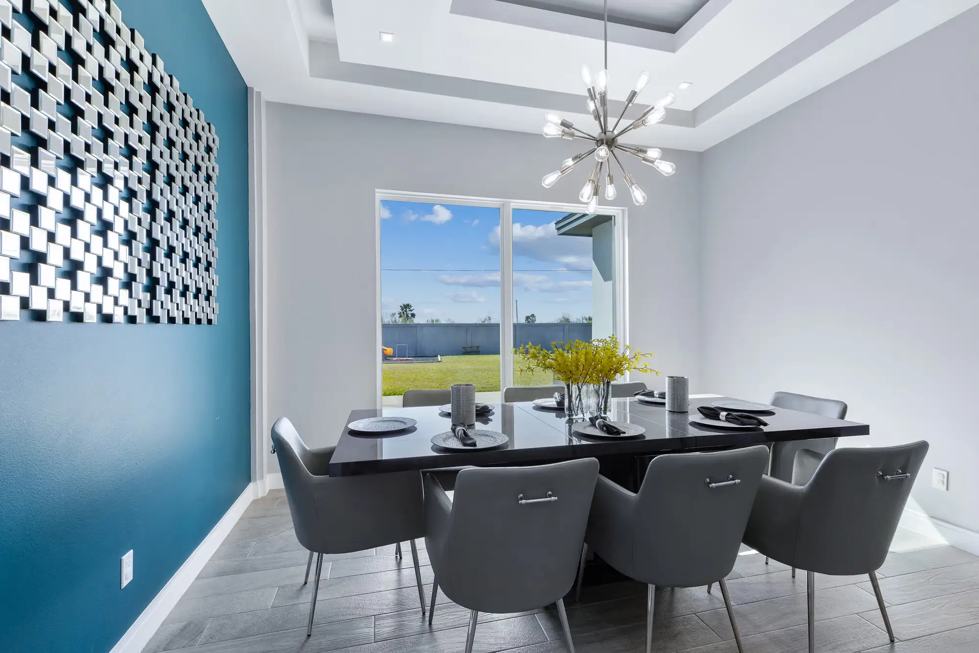 Dining room with a sculptural geometric feature wall and a brass sputnik fixture