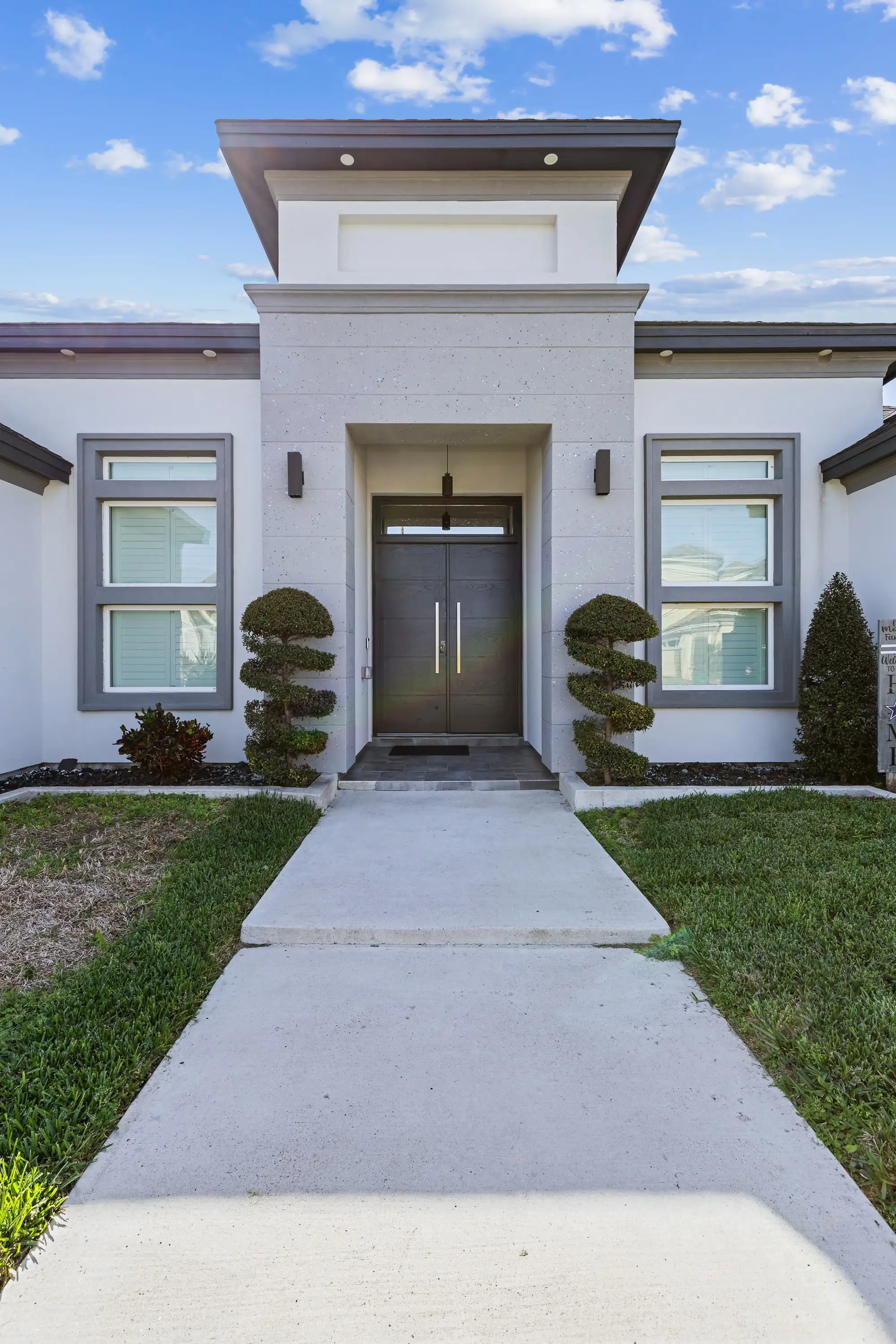 Limestone entry tower with a double-height pivot door