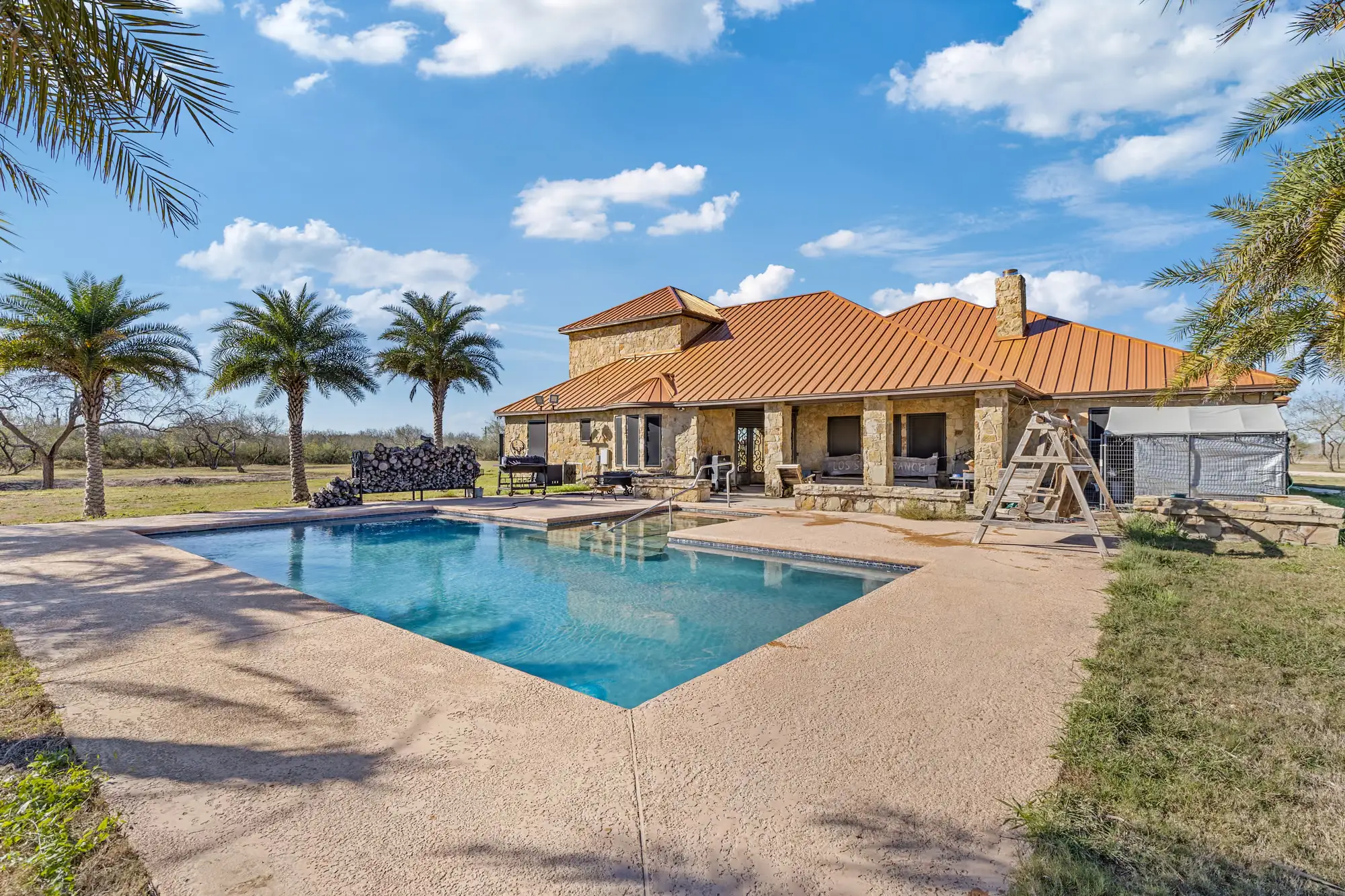 Rectangular pool beside the home’s covered rear porch