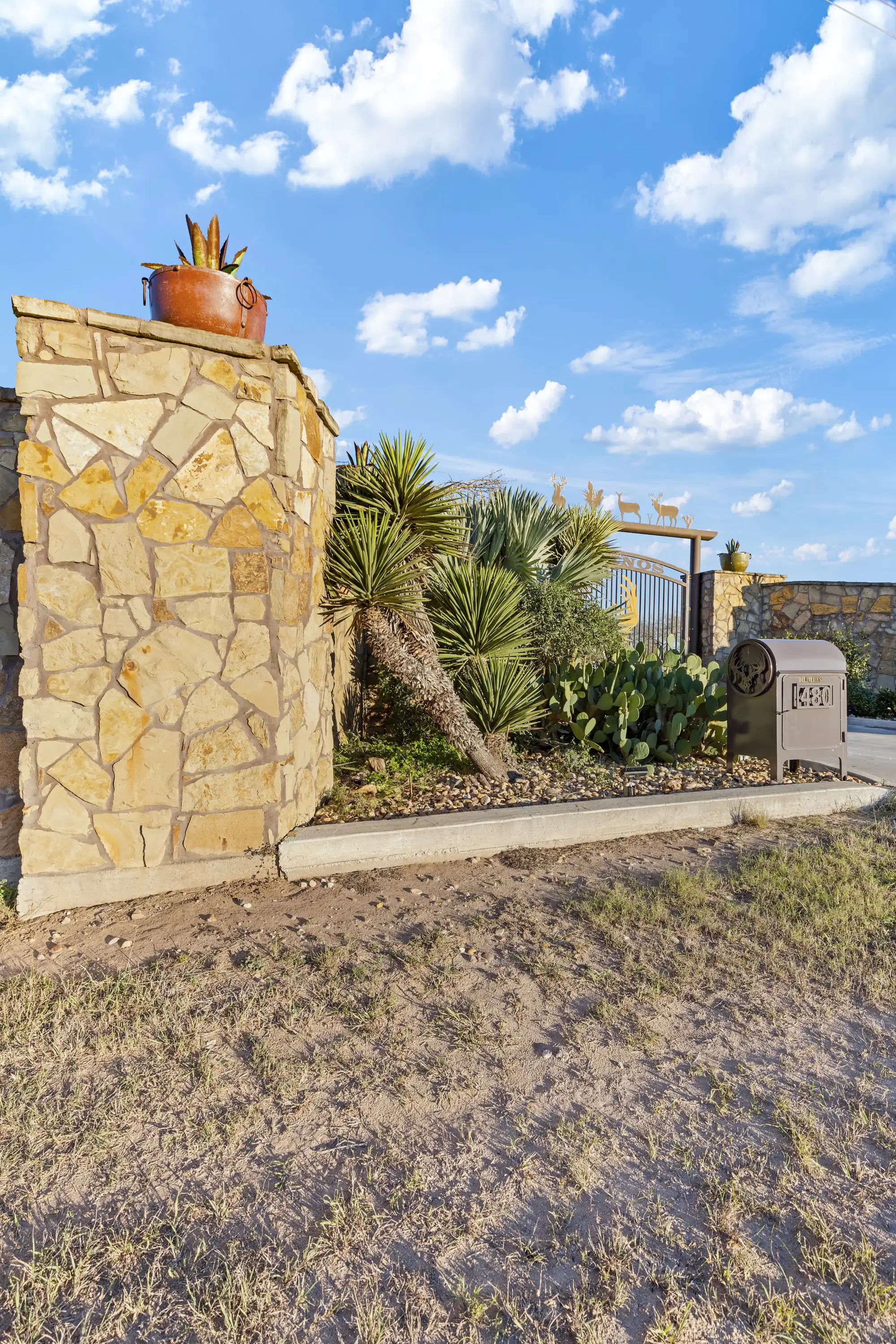 Detail of the rough stone pillar and native planting at the gate